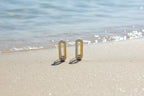 SVORA gold tone stainless steel dangle earrings with pavé cubic zirconia bars and a moving stone detail.