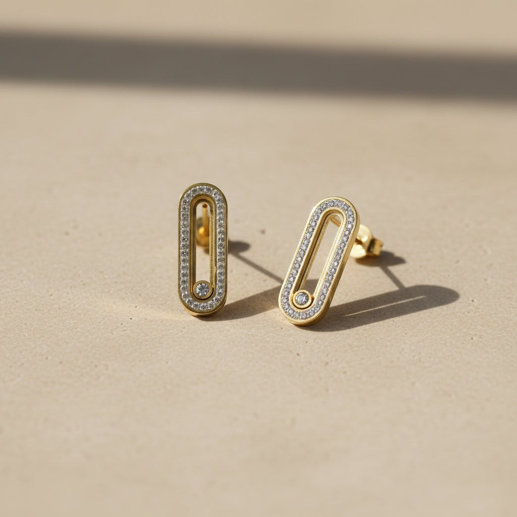 SVORA gold tone stainless steel dangle earrings with pavé cubic zirconia bar and moving stone detail.
