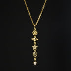 SVORA gold cable chain lariat necklace with daisy, Saturn, star, quatrefoil, and heart charms.