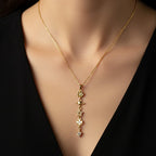 SVORA gold cable chain lariat necklace with daisy, Saturn, star, quatrefoil, and heart charms. 18K gold plated.