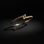 SVORA gold-plated stainless steel crossover bangle bracelet with CZ stones. Waterproof and anti-tarnish.