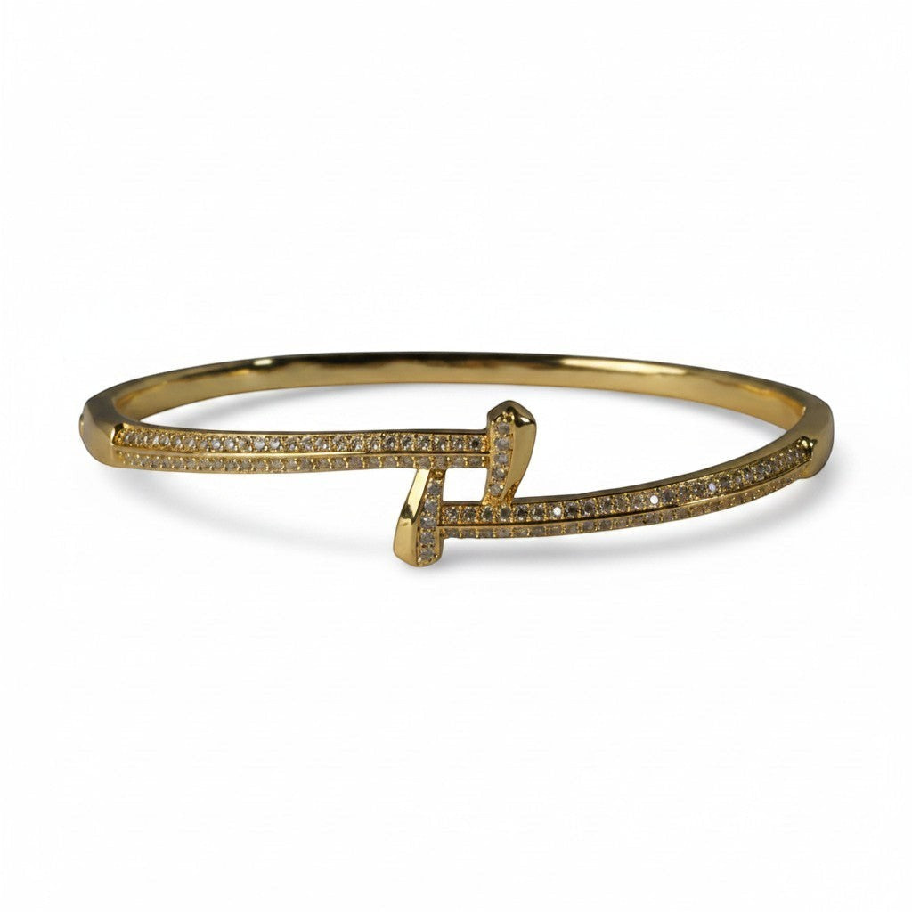SVORA gold plated stainless steel crossover bangle bracelet with cubic zirconia stones.