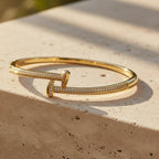 SVORA gold plated stainless steel crossover bangle bracelet with CZ stones. Waterproof and anti-tarnish.