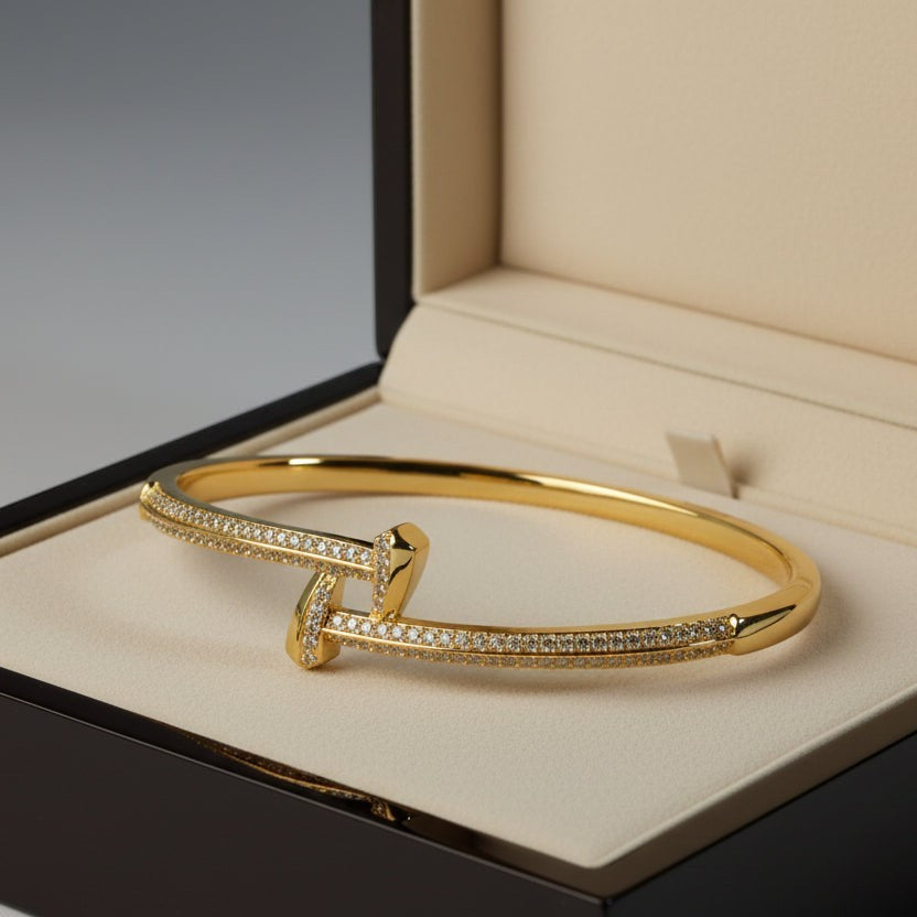 SVORA gold crossover bangle bracelet with cubic zirconia accents, 18K gold plated stainless steel.