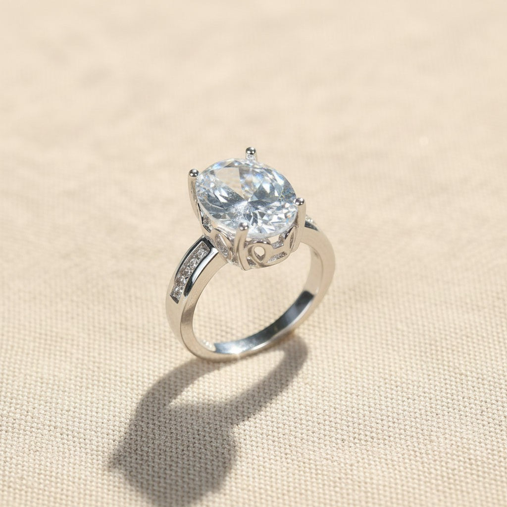SVORA Ethereal Diamond Solitaire Ring with oval-cut clear stone and channel-set baguette band in rhodium-plated stainless steel.