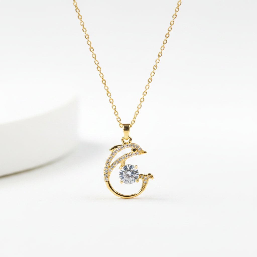 SVORA gold-plated stainless steel necklace with a pavé crystal dolphin pendant holding a large white CZ.