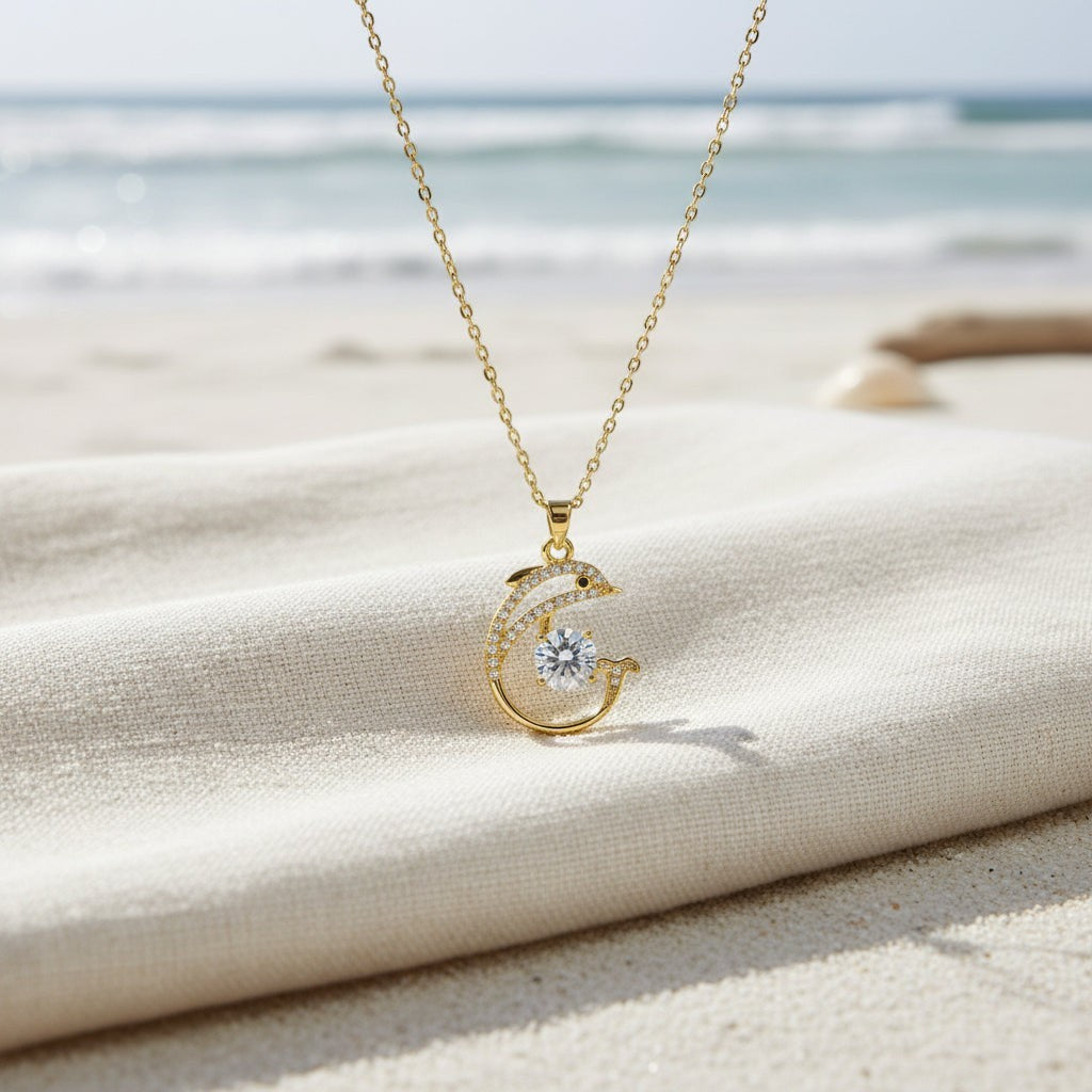 SVORA gold-plated stainless steel dolphin pendant necklace with pavé CZ and large central white CZ. Waterproof.