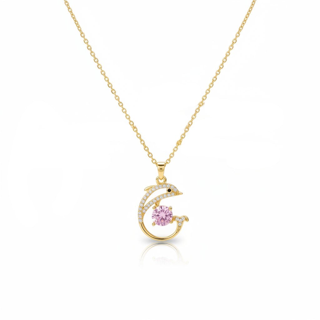 SVORA gold plated stainless steel necklace with a pavé dolphin pendant holding a pink cubic zirconia stone.