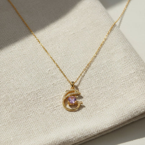 SVORA gold plated stainless steel necklace with a pavé dolphin pendant holding a pink CZ stone.