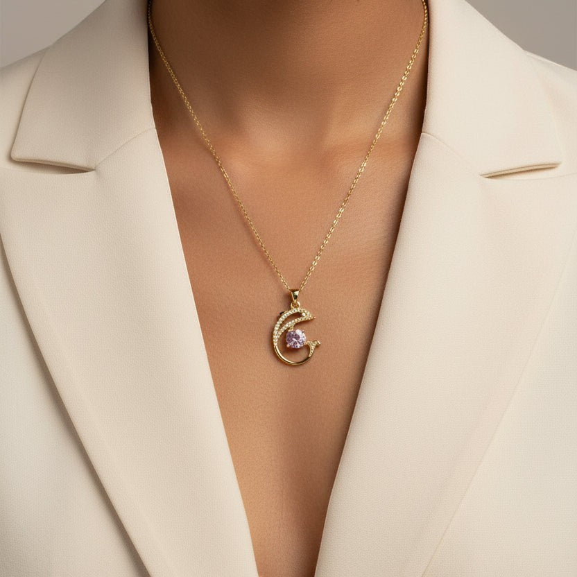 SVORA gold plated dolphin pendant necklace with pink cubic zirconia and pavé details.