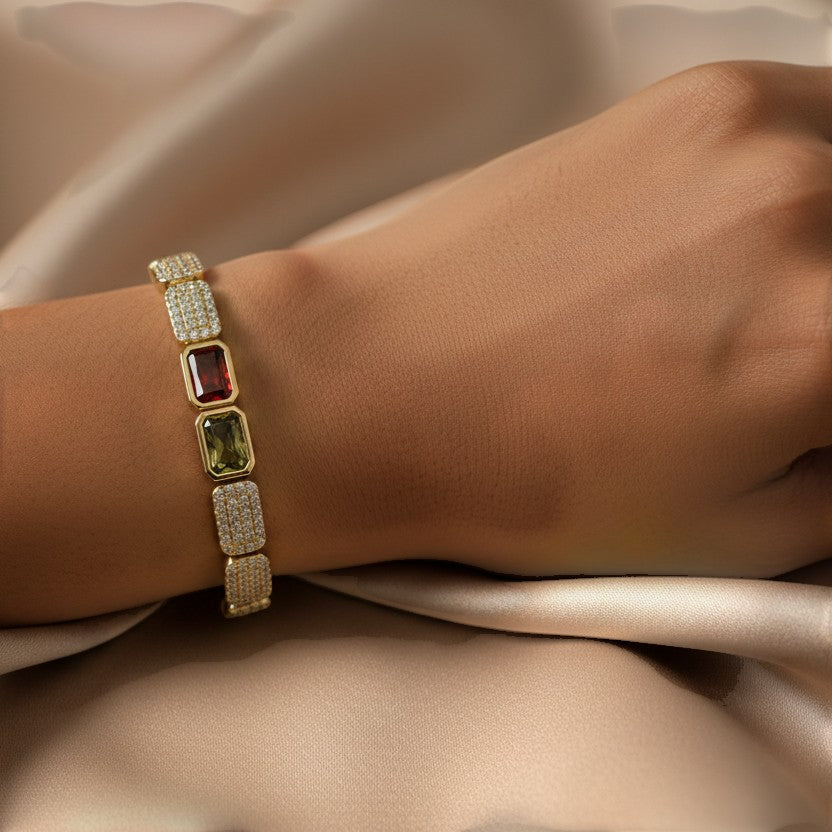 SVORA gold-tone stainless steel bracelet with pave crystals and rectangular red and green gems.