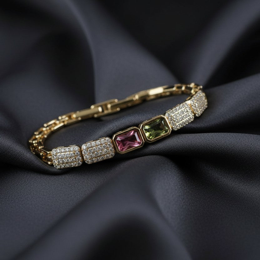 SVORA gold-tone stainless steel bracelet with pink and green rectangular gems surrounded by small crystals.