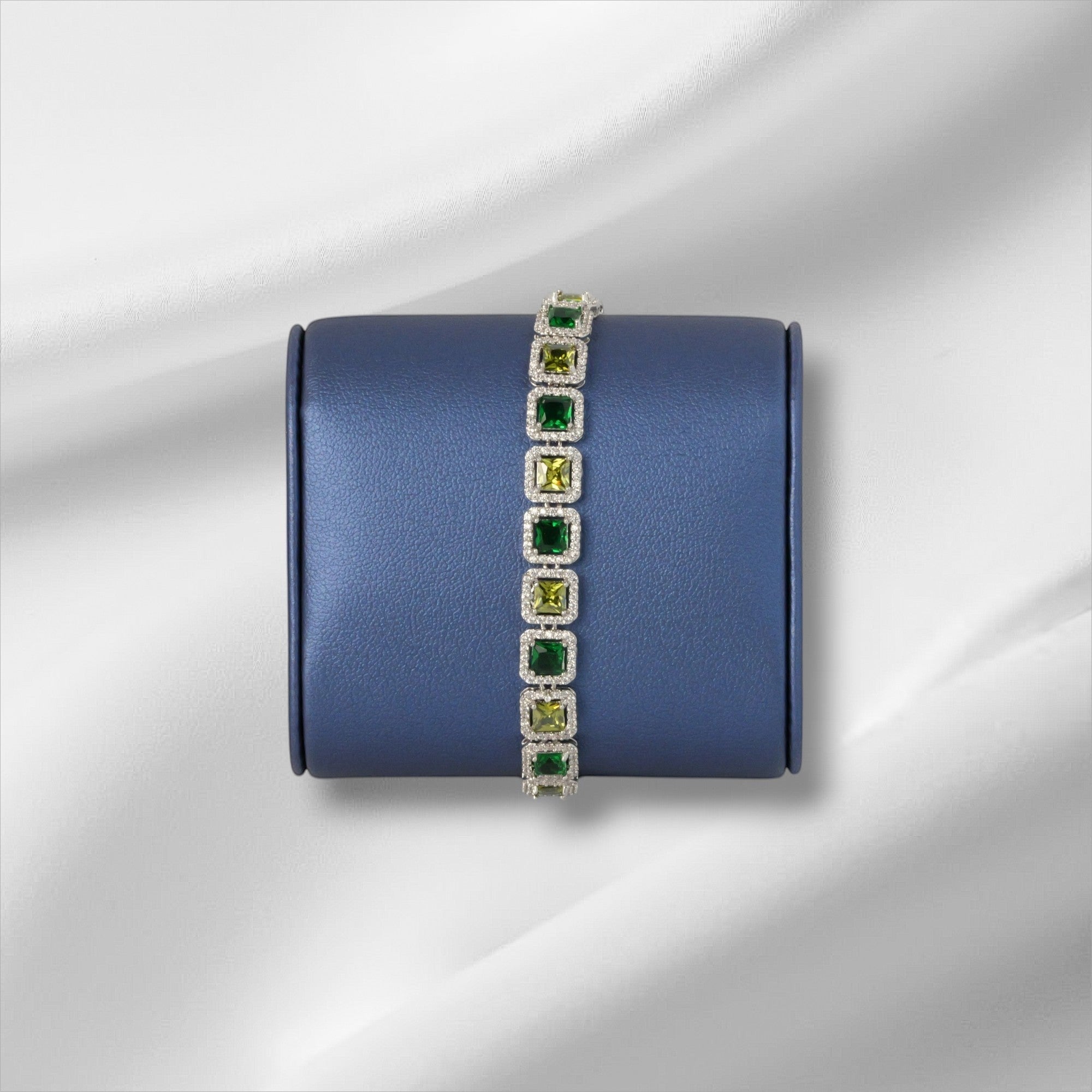 SVORA Emerald Halo Tennis Bracelet with princess-cut emerald, olive, and clear CZ stones set in silver.