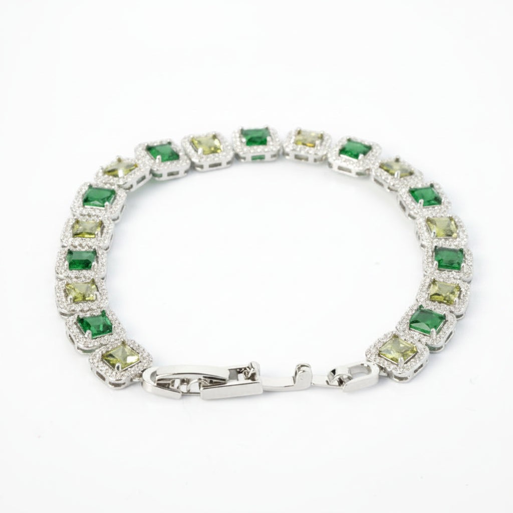 SVORA Emerald Halo Tennis Bracelet with princess-cut emerald, olive, and clear CZ stones set in rhodium-plated silver with a fold-over clasp.