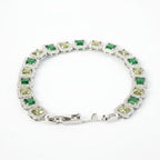 SVORA Emerald Halo Tennis Bracelet with princess-cut emerald, olive, and clear CZ stones set in rhodium-plated silver with a fold-over clasp.