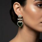 SVORA gold-tone drop earrings with emerald crystal heart, pavé bow, and heart stud.