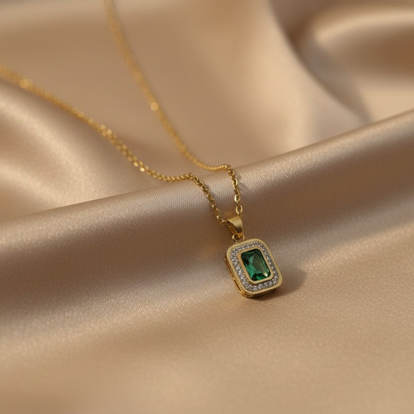 SVORA gold-plated stainless steel necklace with a rectangular emerald pendant surrounded by small clear stones.