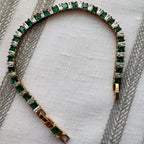 SVORA Emerald Tennis Adjustable Bracelet with alternating emerald green and clear square-cut stones, 18k gold-plated stainless steel.