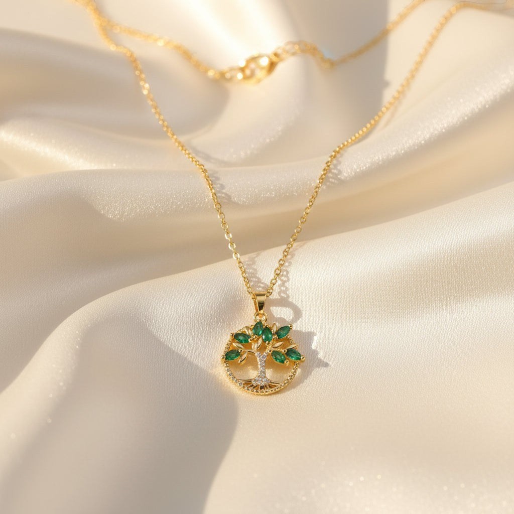 SVORA gold plated stainless steel necklace with emerald marquise CZ leaves and white CZ accents forming a Tree of Life pendant.