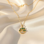 SVORA gold plated stainless steel necklace with emerald marquise CZ leaves and white CZ accents forming a Tree of Life pendant.