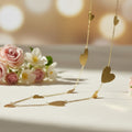 SVORA gold-tone stainless steel long drape necklace with multiple polished heart motifs.