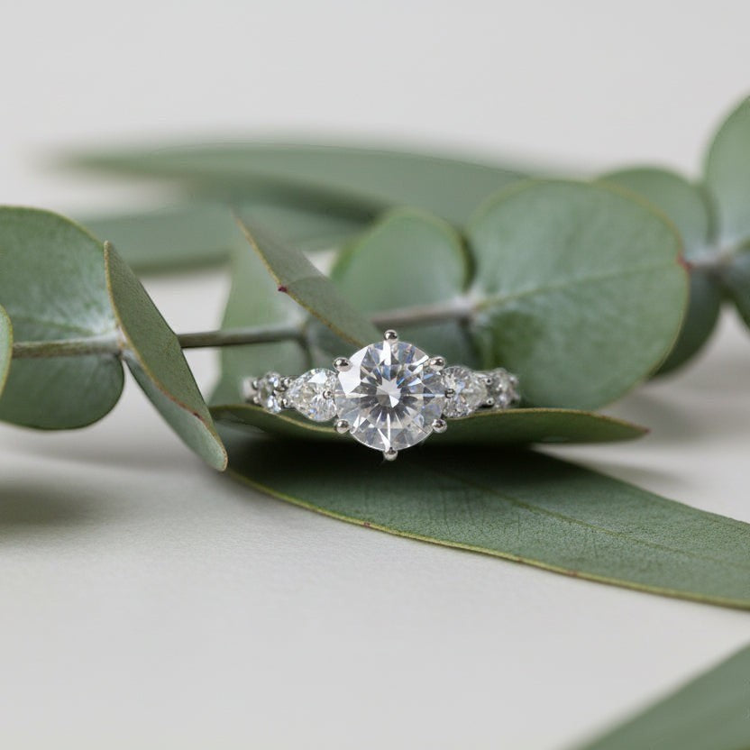SVORA Ethereal Amour Solitaire Ring with round-cut center stone and heart-cut accent stones on a silver band.