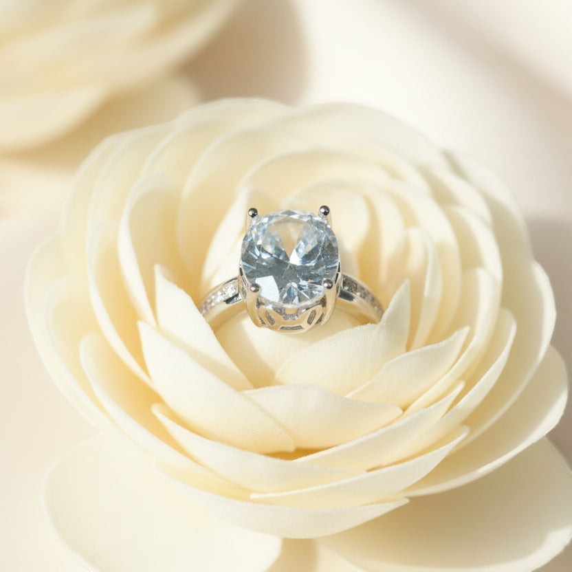 SVORA Ethereal Diamond Solitaire Ring with oval-cut clear stone and baguette band on a cream rose.