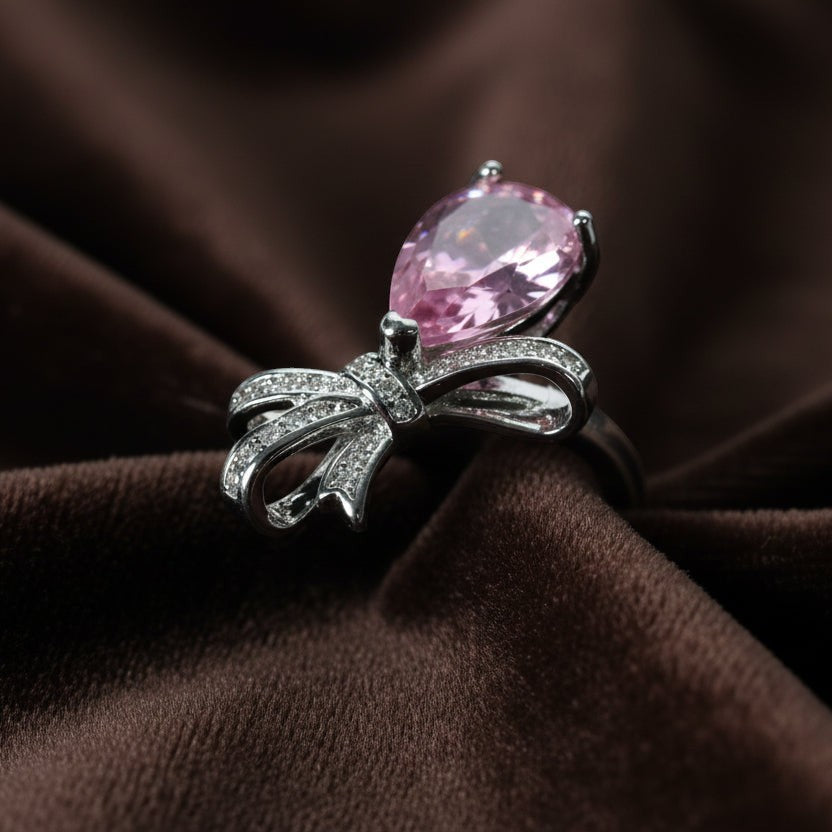SVORA Ethereal Rose Ribbon Ring with pear-cut pink stone and pavé clear stones on a silver band.