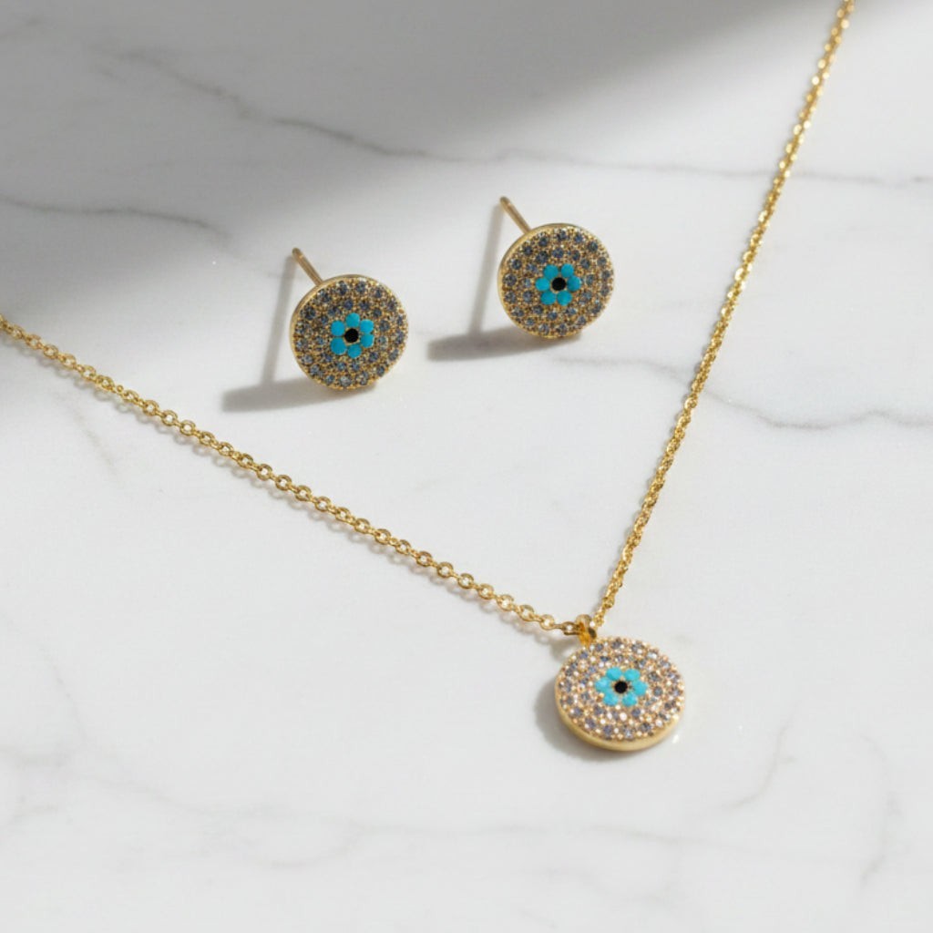 SVORA gold tone stainless steel evil eye necklace and earrings set with cubic zirconia and turquoise detail.