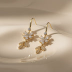 SVORA Flora Stones Dangler Earrings with gold-tone stainless steel, cubic zirconia flowers and leaf details.