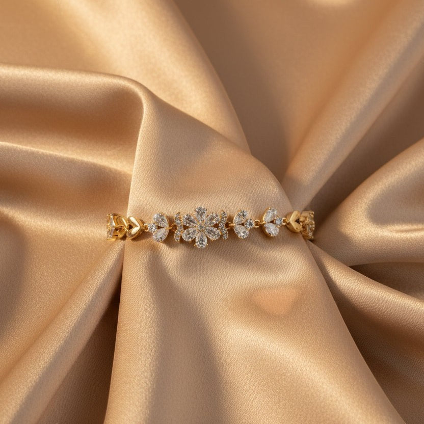 SVORA gold plated stainless steel bracelet with CZ flower and leaf links, adjustable fold-over clasp.