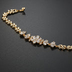 SVORA gold plated stainless steel bracelet with CZ flower and leaf links. Ornate botanical design.
