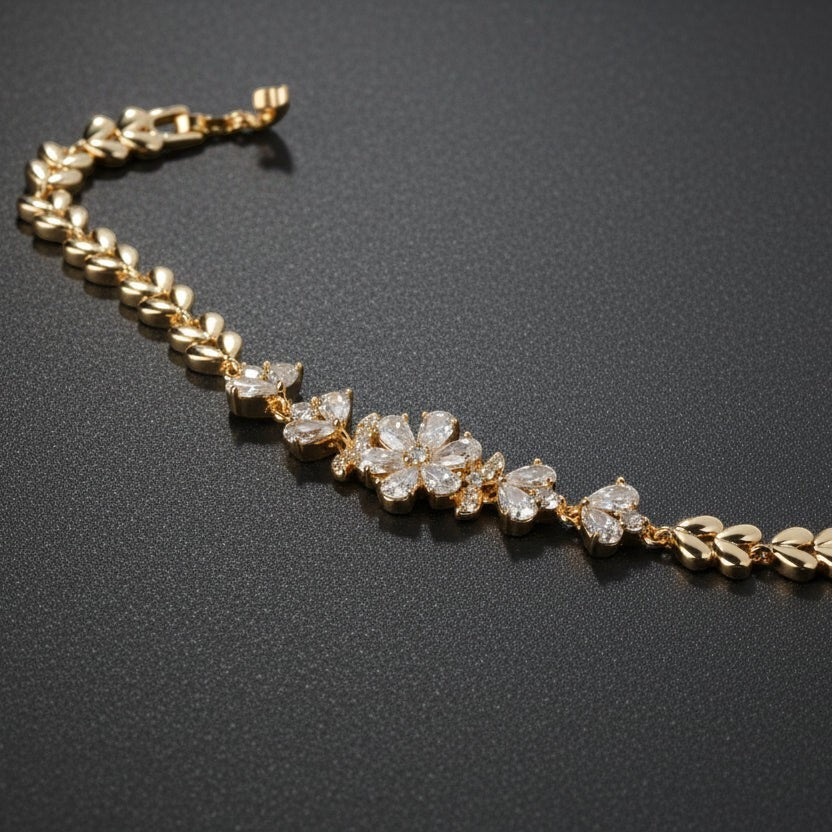 SVORA gold plated stainless steel bracelet with CZ flower and leaf links. Ornate botanical design.