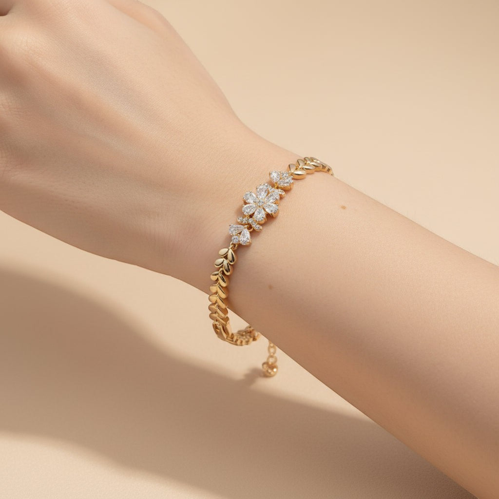 SVORA gold plated stainless steel bracelet with CZ flowers and leaf links. Adjustable fold-over clasp.