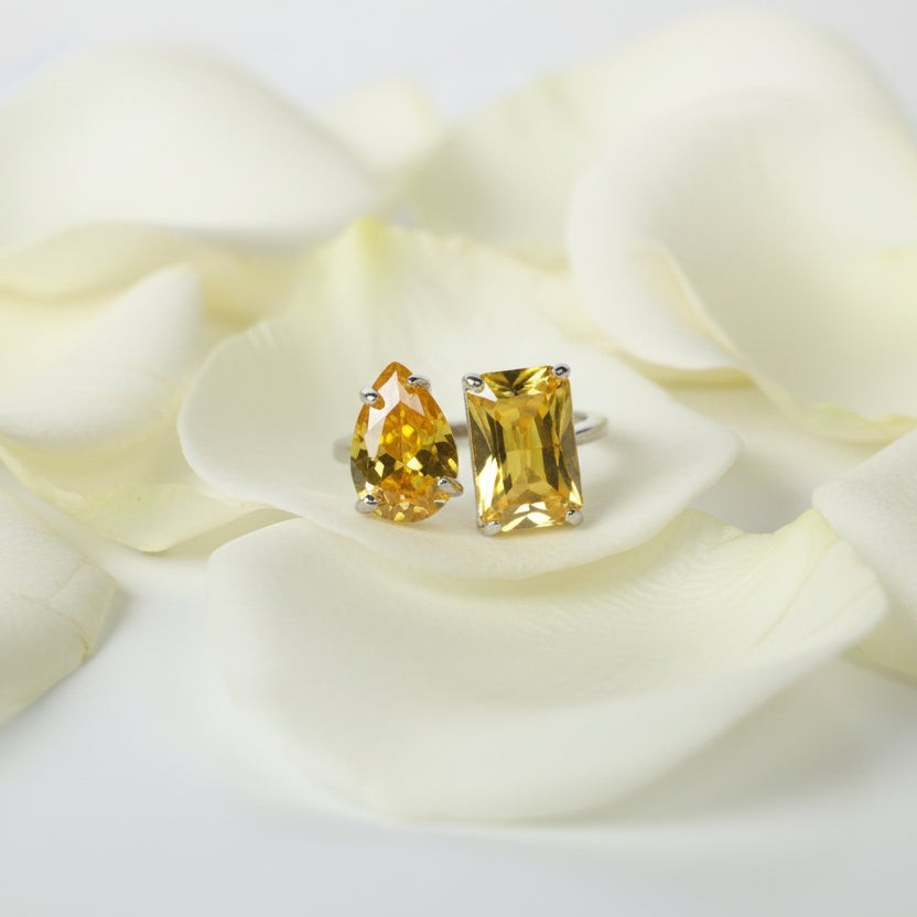 SVORA Toi et Moi Sunshine Garnet Ring with two yellow stones, one pear-cut and one emerald-cut, on a silver band.