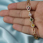 SVORA geometric multicolor bracelet with citrine yellow, peridot, pink, and garnet CZ halo stones on gold chain.