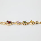 SVORA geometric multicolor bracelet with garnet, pink, peridot, and citrine stones in CZ halos, linked by gold chain. 18K gold plated.