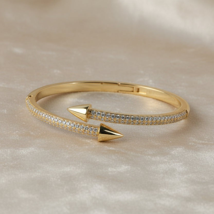 SVORA gold plated stainless steel bypass bracelet with two pavé diamond arrowheads