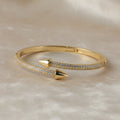 SVORA gold plated stainless steel bypass bracelet with two pavé diamond arrowheads