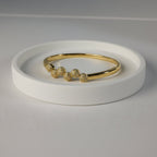 SVORA gold plated stainless steel bangle bracelet with six pavé cubic zirconia domes in a row.