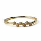 SVORA gold plated stainless steel bangle bracelet with six pavé cubic zirconia domes in a row.