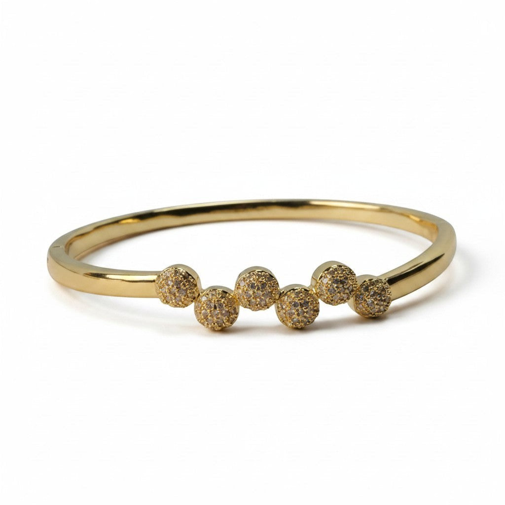 SVORA gold plated stainless steel bangle bracelet with six pavé cubic zirconia domes in a row.