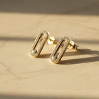 SVORA gold tone stainless steel dangle earrings with pavé cubic zirconia bar and moving stone detail.