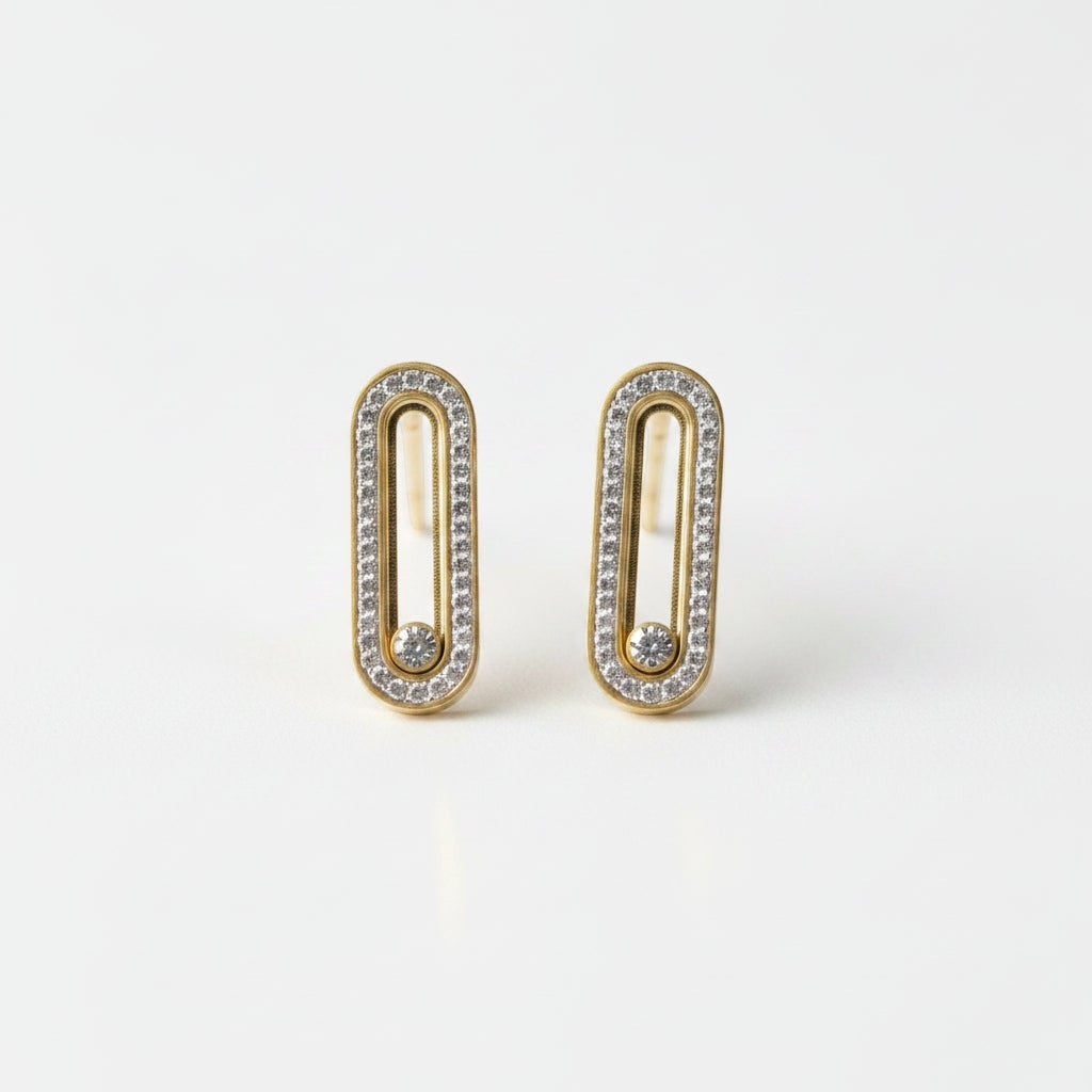 SVORA gold tone stainless steel dangle earrings with pavé cubic zirconia bars and a central moving stone.