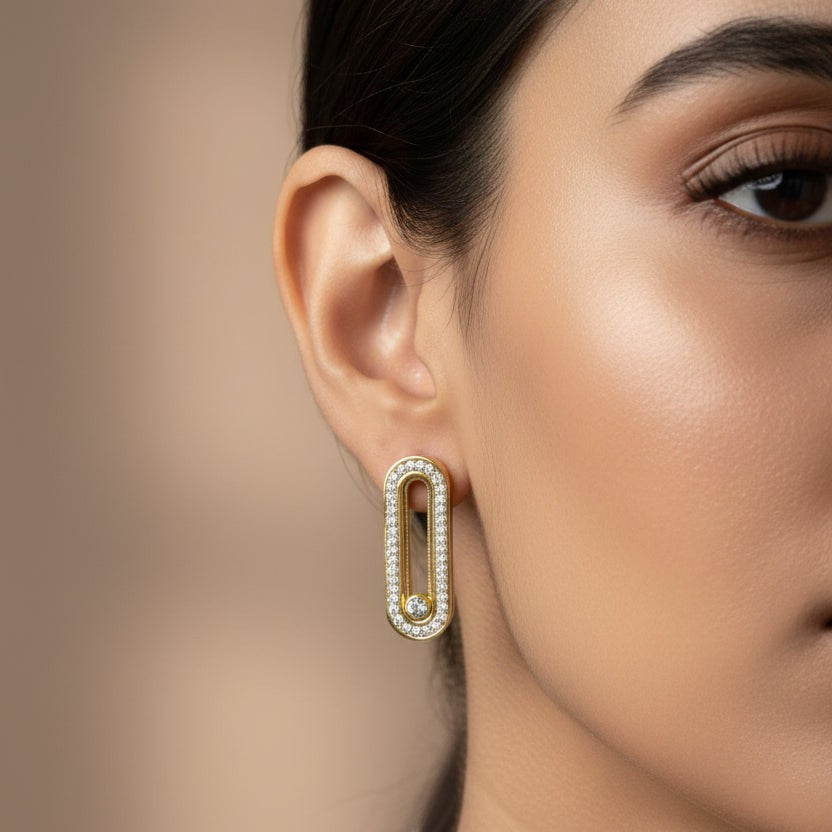 SVORA gold tone stainless steel dangler earrings with pavé cubic zirconia bar and moving stone detail.
