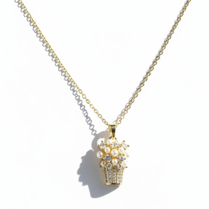 SVORA gold-tone stainless steel necklace with a basket pendant adorned with pearls and cubic zirconia stones.