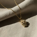 SVORA gold-plated stainless steel necklace with a pendant shaped like a basket filled with pearls and sparkling stones.