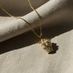SVORA gold-plated stainless steel necklace with a pendant shaped like a basket filled with pearls and sparkling stones.