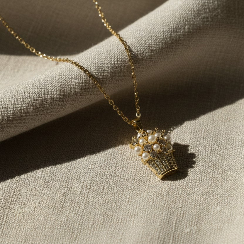 SVORA gold-plated stainless steel necklace with a pendant shaped like a basket filled with pearls and sparkling stones.