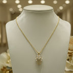 SVORA gold tone stainless steel necklace with a pendant shaped like a basket filled with pearls and clear stones.